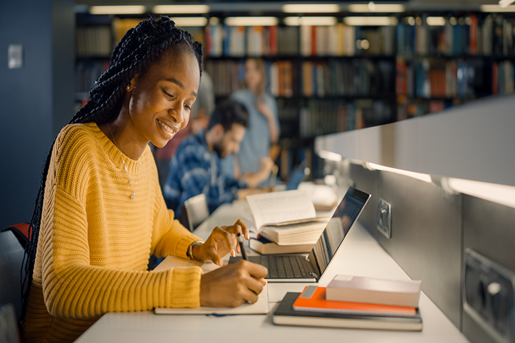 student looking at computer in the library