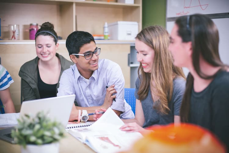 Group of students sitting around a table and talking