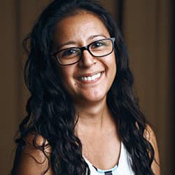 Image of Melinda Rossi from the shoulders up smiling with her teeth.