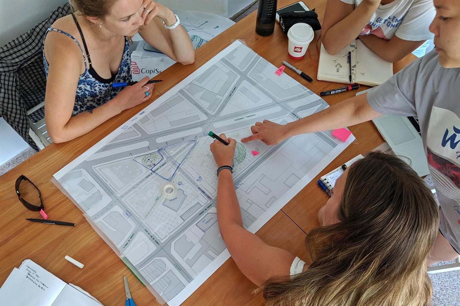 Group of students around a table working on an architecture design map