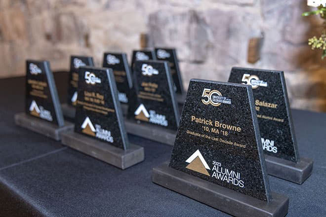 2023 Alumni Award plaques lined up on a table.