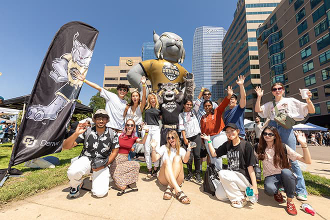 Group of students around Mighty Milo posing for a photo at CU Denver Block Party.