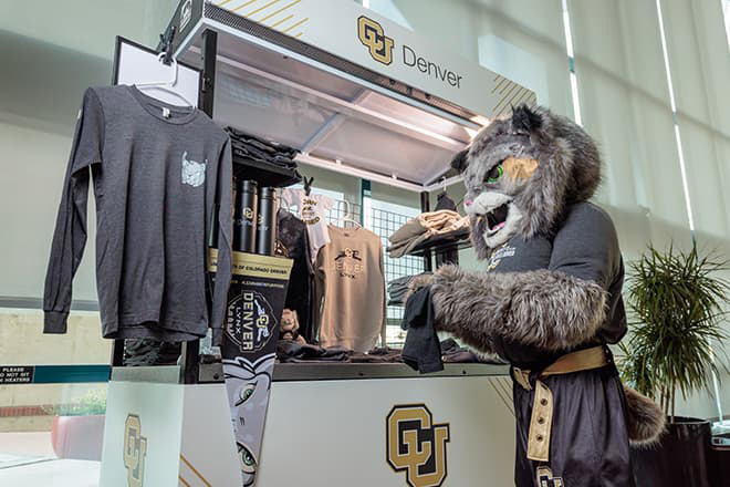 Milo the Lynx mascot shopping at a Swag Shop in the Lawrence Street Center.