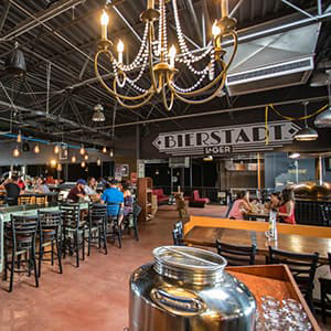 Bierstadt Lagerhaus space featuring people at the bar and surrounding tables.