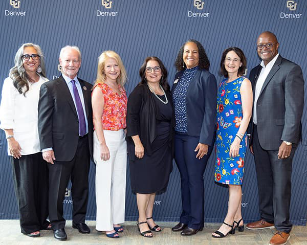 2024 SEHD Alumni Leadership Award Recipients in business professional clothing, smiling and standing against a blue backdrop.