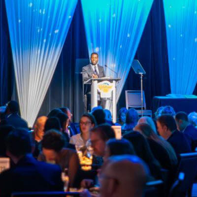 Brian Sherrod of CBS Colorado speaks at a podium for the Denver Regional Council of Governments awards celebration.