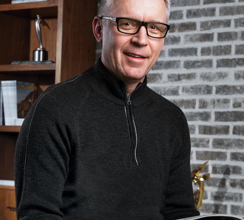 Image of Robin Thurston in a black sweater with glasses on and a half-smile.