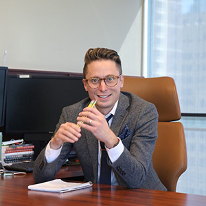 Todd Haggerty at his desk smiling holding three sharpened pencils