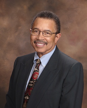 Headshot of Kenneth Taylor smiling in business suit with tie