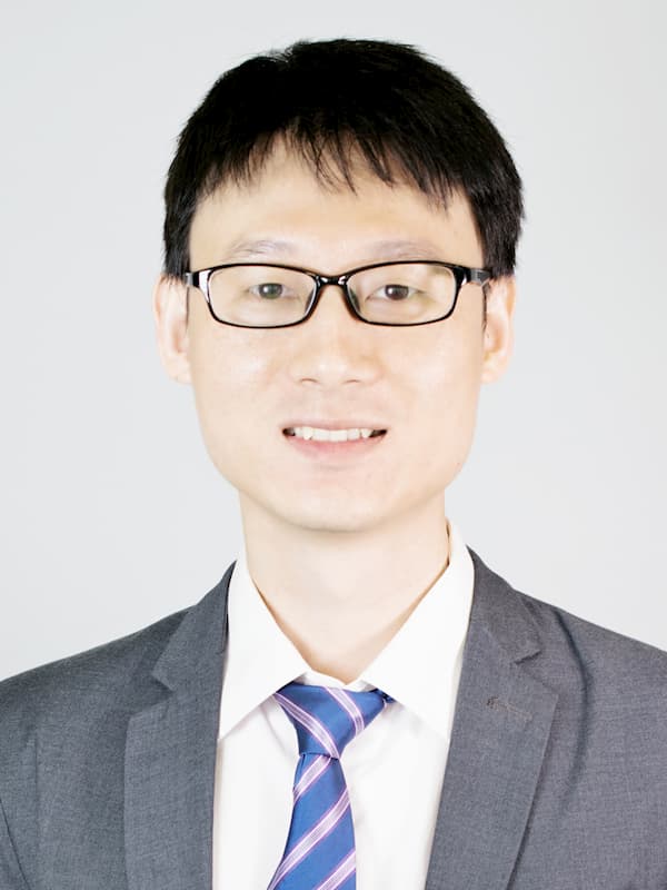 headshot of Feng Li smiling in business suit and tie