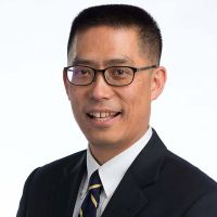 Headshot of Jaedo Park from the shoulders up smiling in business suit.