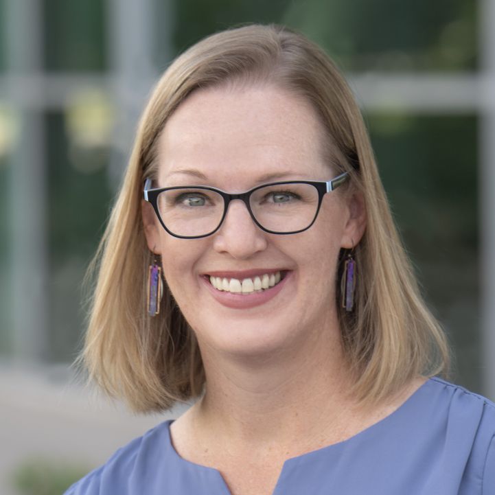 Headshot of Kim Koole from shoulders up smiling in business casual attire