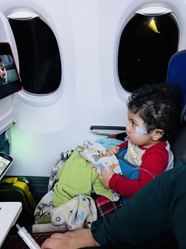 Young boy sitting in seat on airplane using the GoTo postural seat