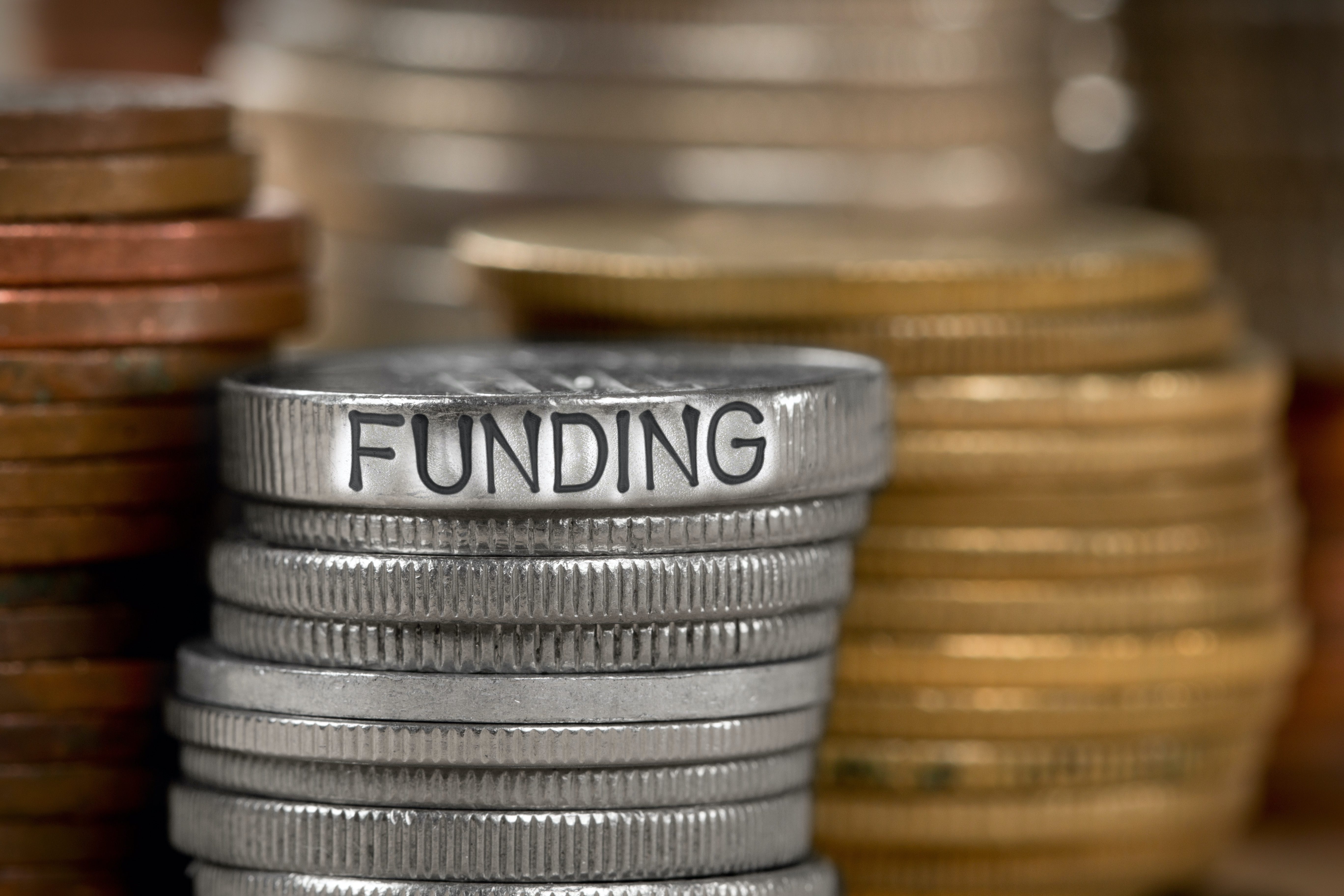 Stacks of coins with funding written on top coin.