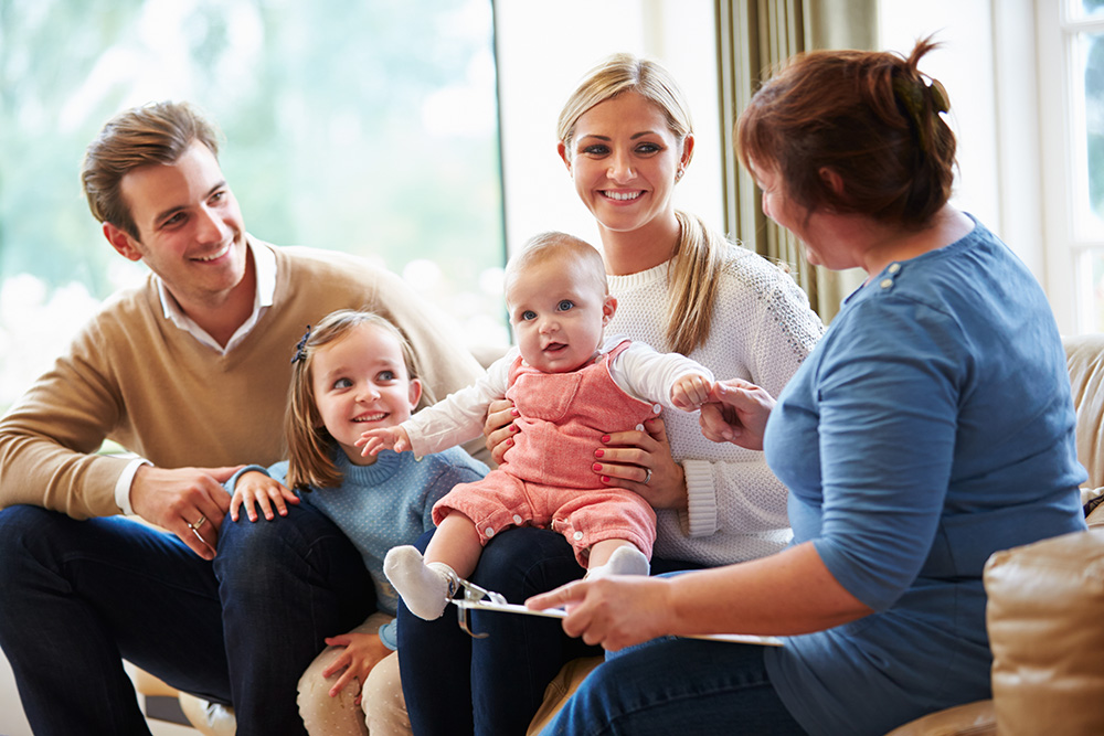 Parents with two happy children and therapist.