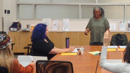 A trainer engages with students in a conference room