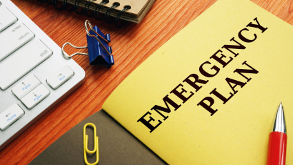 A file folder titled Emergency Plan sits on a desk