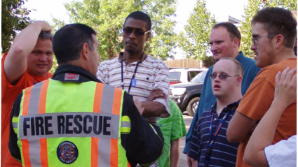 A group of people with various intellectual disabilities speak with a fire rescue trainer