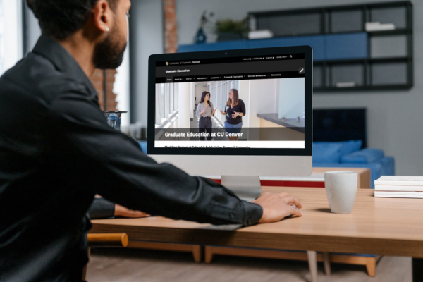 Man looking at computer with graduate education website